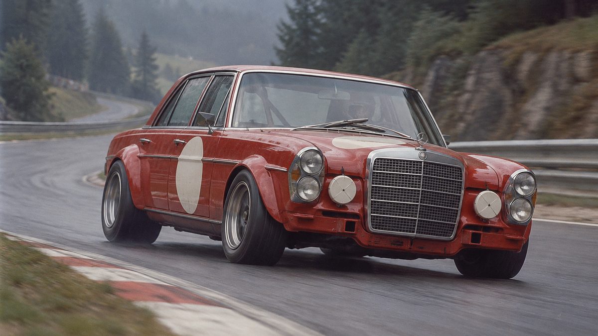 Roter Mercedes 300 SEL 6.8 AMG als Rennwagen auf einer Waldstrecke